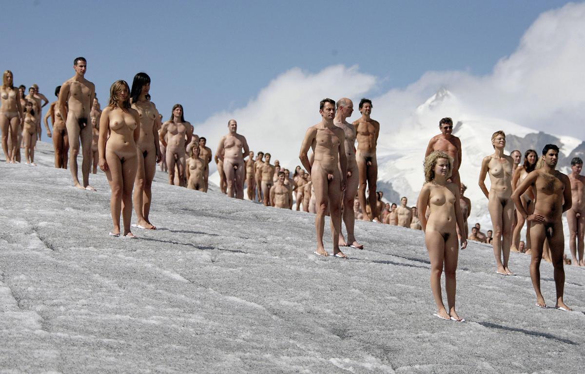 Naked volunteers stand atop Aletsch glacier,